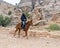 Bedouin riding an Arabian steed along the road leading from Petra - the capital of the Nabatean kingdom in Wadi Musa city in Jorda