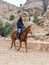 Bedouin riding an Arabian steed along the road leading from Petra - the capital of the Nabatean kingdom in Wadi Musa city in Jorda