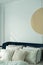 Bedroom corner navy blue velvet bed with soft pillows setting decorated with gold circular stainless and navy blue paint wall in