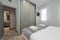 Bedroom with gray sliding door wardrobe, blanket on the bed and clean