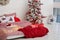 Bedroom interior with Christmas pillows, bed linen and red plaid. Cozy Decorated bedroom for Christmas holidays with tree and gift