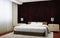 Bedroom interior executed in dark brown tones with light wood furnishings and white carpet.
