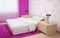 Bedroom interior made in light colors with light wood furnishings, pink carpet and curtains and wallpaper with hearts.