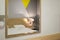 The bedroom interior is reflected in the mirror on the wall. Reflection in the mirror: white bed, luminous night light, bedside ta