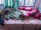 The bedroom is a mess. A child\\\'s room with a messy bed and pillows, bolsters and quilts that have not been tidied up