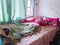 The bedroom is a mess. A child\\\'s room with a messy bed and pillows, bolsters and quilts that have not been tidied up.