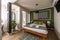 Bedroom with queen bed with green cushions, green wall