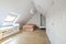 Bedroom with white cabinet doors, bed with striped bedspread, sloping ceilings, and teen bed with skylight above