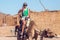 Beduins and tourits ride a camels in the desert