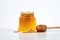 A bee sits on a honeycomb - a jar of honey white background