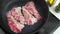 beef bacon frying in a pan marbled thin beef