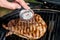 Beef blade steak grilling on barbecue grill plate with meat thermometer. Backyard BBQ grill cooking