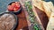 Beef bone marrow grill with pickle and pate sides serve on wood plate