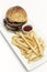 Beef burger with french fries platter on white table