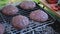 Beef burgers cutlets are roasting on the charcoal barbecue grill