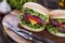 Beef burgers on a wooden board with aromatic spices