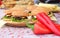 Beef and cheese burgers with green salad and sauce lying on a wooden plate at street food festival