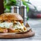 Beef Egg and Bacon Burger Served in Restaurant. American fastfood. Tasty Gourmet on Wooden Table.Beef burgers on wooden plate