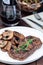 Beef filet with sauteed brown mushrooms and thyme, on wooden background, vertical