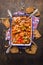 Beef goulash with spoons and rye bread on rustic wooden background