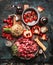 Beef goulash of young bulls with vegetables and cooking ingredients , preparation on cutting board and dark rustic background