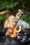 Beef kebab cooking on skewer with flame sparks barbecue on bonfire in forest at travel