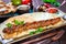 Beef kebab with pita bread, tomato sauce and vegetables on wooden background.