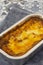 Beef lasagne or lasagna ready bfrozen meal cooked in a metal baking tray on a blue tea towel.