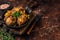 Beef oxtails stew with wine and vegetables in a pan. Dark background. Top view. Copy space