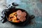 Beef patties for burger with grilled pumpkin in a cast iron pan