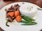 Beef Salpicao, with a serving of rice, green beans and carrots. Delicious Filipino cuisine. Cooked medium rare