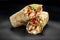 Beef shawarma on a dark background. Shawarma with beef in pita bread