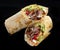 Beef shawarma on a dark background. Shawarma with beef in pita bread