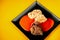 Beef shine, spicy tomato sauce and dumpling on black square plate on yellow background