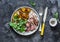 Beef steak and baked young potatoes - delicious lunch on a dark background, top view