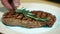 Beef steak is being decorated with green rosemary in expensive restaurant, close up.
