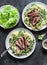 Beef steak with mashed potatoes and creamy green peas sauce on dark background, top view