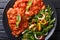 Beef steak with pizzaiola sauce and fresh salad close-up. horizontal top view