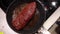 Beef steak roast in pan. Meat frying, steam from the dish, top view.