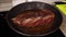 Beef steak roast in pan. Meat frying, steam from the dish, top view.