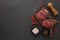 Beef steaks on cutting board and spices on black slate background. Top view. Steak menu