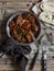 Beef stew in a frying pan on a wooden rustic table.