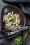 Beef stroganoff with mushrooms in a plate with cremini and champignons. Black background. Top view