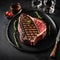 Beef T-Bone steak or aged wagyu porterhouse grilled beef steak Medium rare on a black table - 1