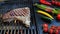 Beef T-Bone steak on the cooking grill with grilled vegetables. Slow motion. Close up