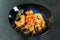 Beef tahan fried Japanese rice with vegetables and slices of beef in a black plate