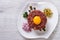 Beef tartare with egg close up on the table. top view