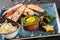 Beef tartare served with an egg yolk, chopped green onions, toast and butter in plate on dark stone background. Clean eating