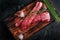 Beef tenderloin on a wood Board with salt and thyme top view