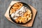 Beef tongue in creamy mushroom sauce. With baked potatoes in a rustic way. In a cast-iron pan with a wooden stand. View from above